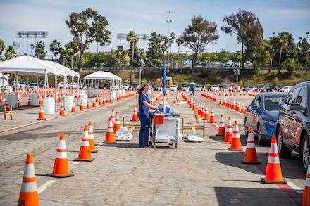 Women in scrubs helps with vaccines in a parking lot