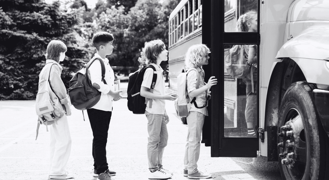 A group of kids getting on a school bus.