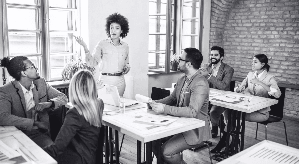 A woman leading a discussion with her other colleagues.