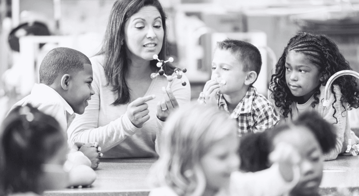 A teacher in a classroom with a group of students.